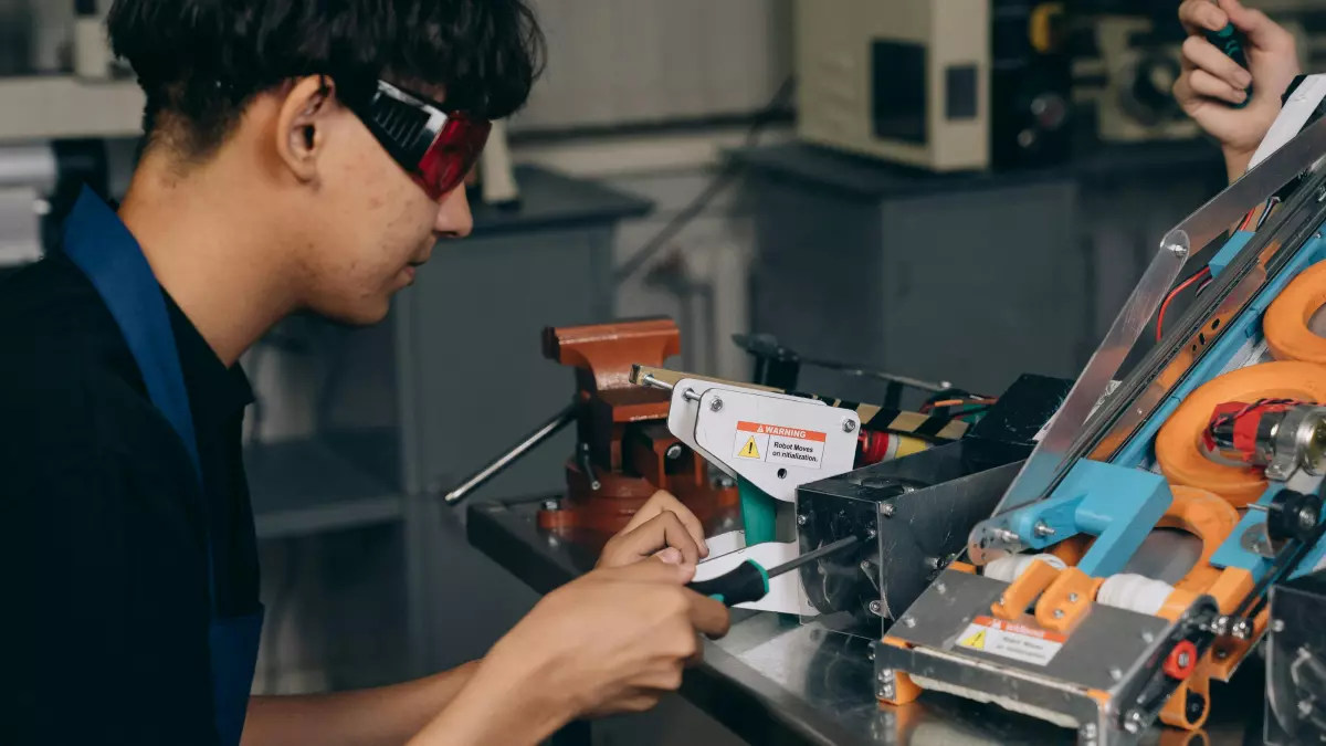 A person is working on a machine with wires and components