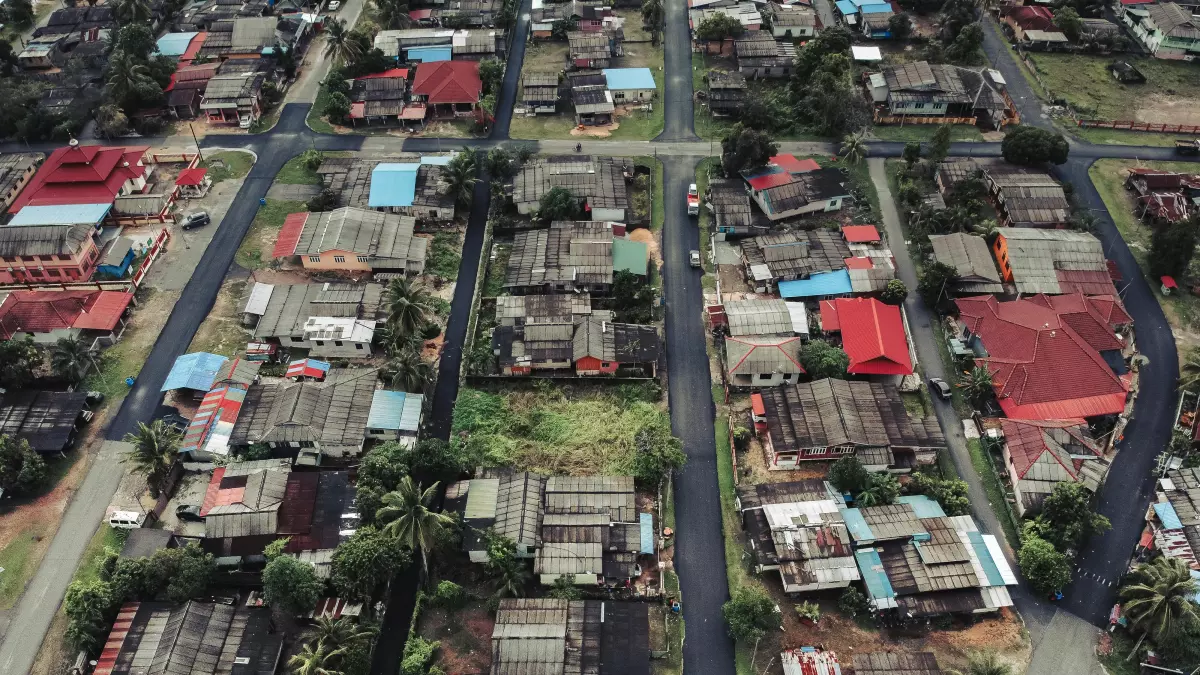 An aerial view of a suburban area with houses, roads, and trees