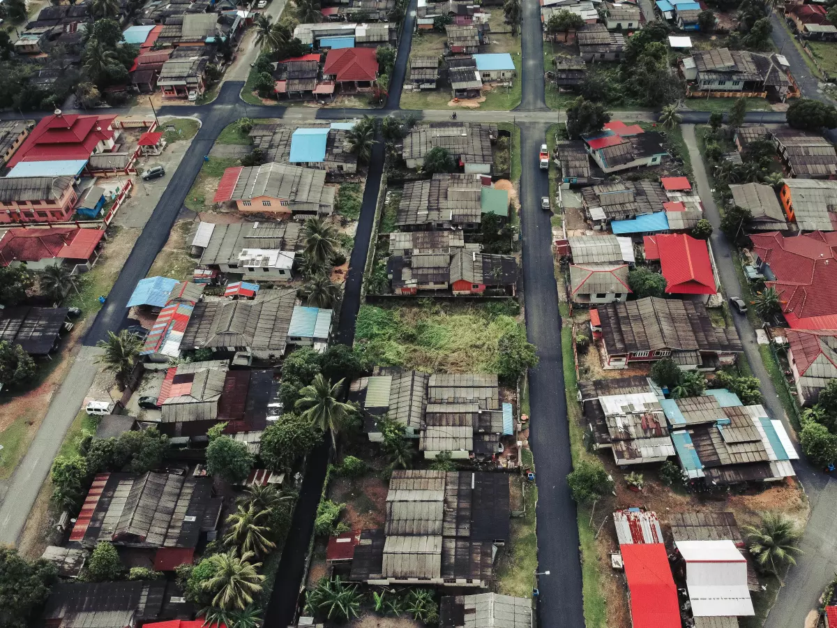 An aerial view of a suburban area with houses, roads, and trees