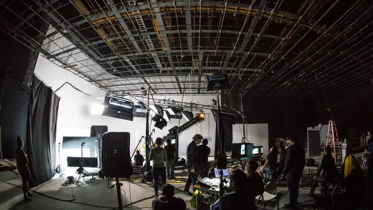 A film set with a lot of people, cables, and equipment