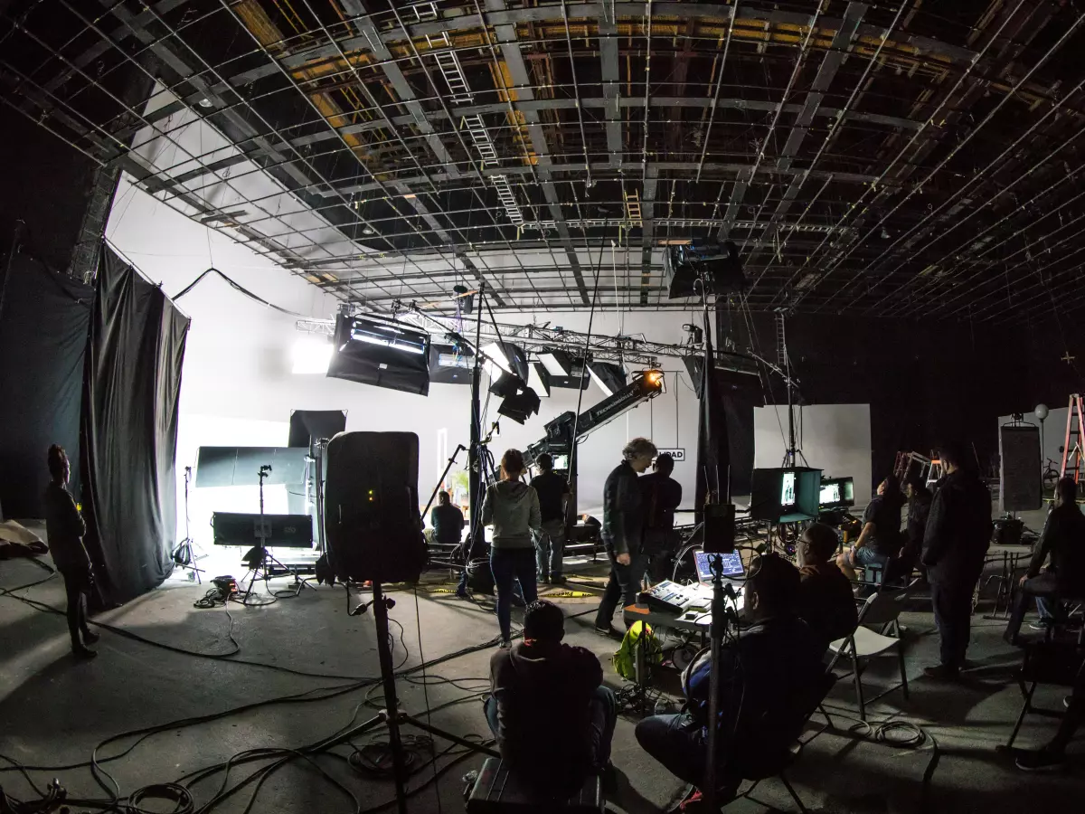 A film set with a lot of people, cables, and equipment