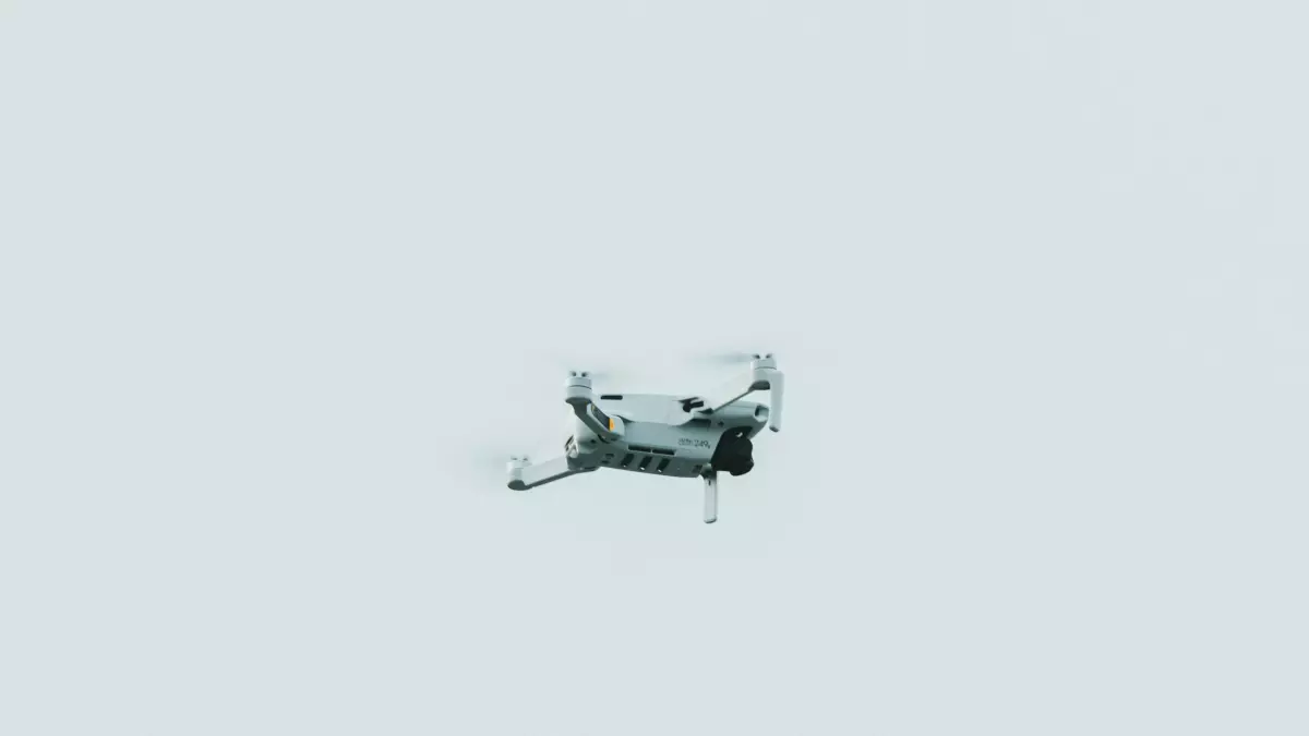 A drone hovering in the air with a white background.