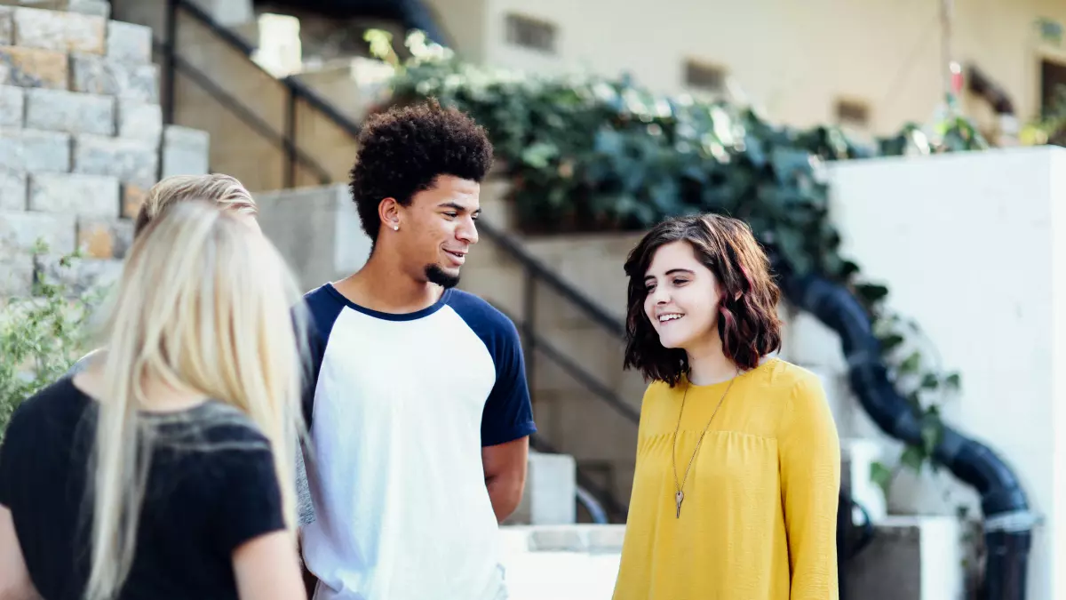 Group of people laughing and chatting in a casual setting.