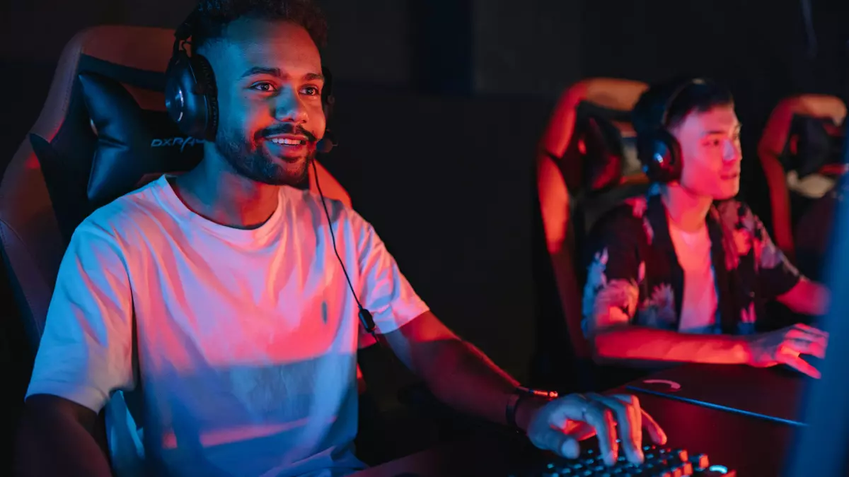 Two young adults wearing gaming headsets play video games in a dimly lit room.