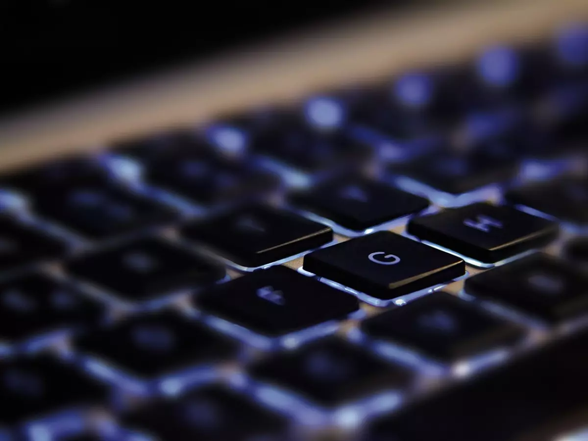 A close-up of a computer keyboard with a glowing G key