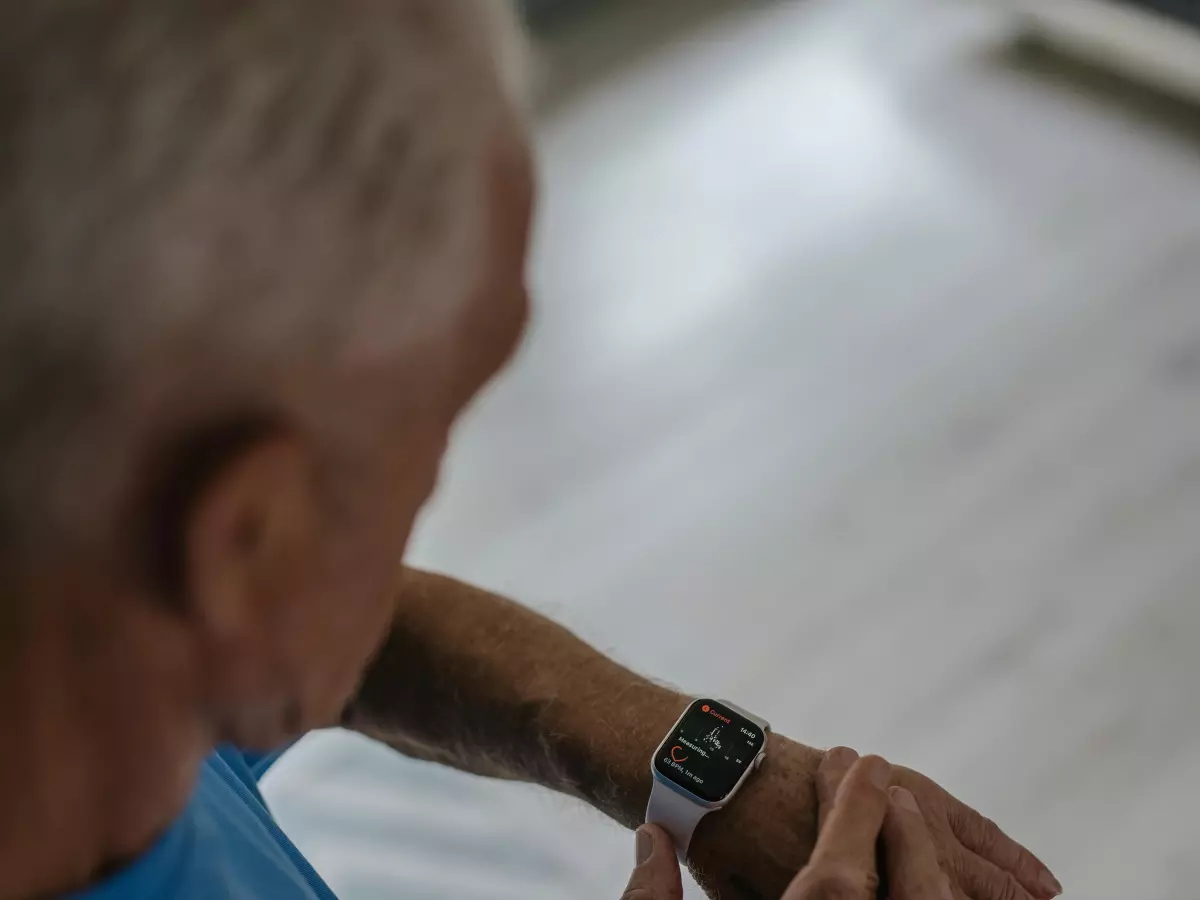 A man wearing a smartwatch on his wrist, viewed from above