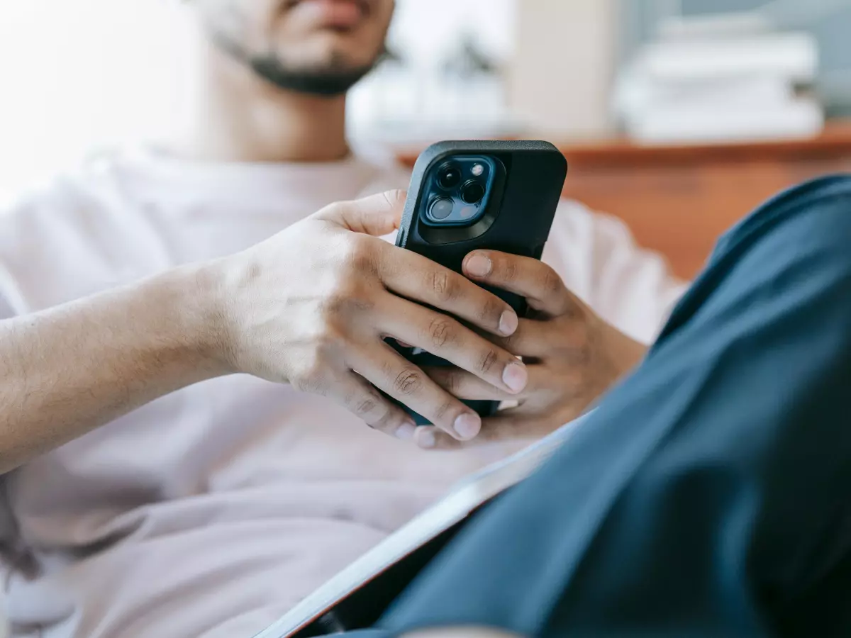 A man is using his phone while sitting down.