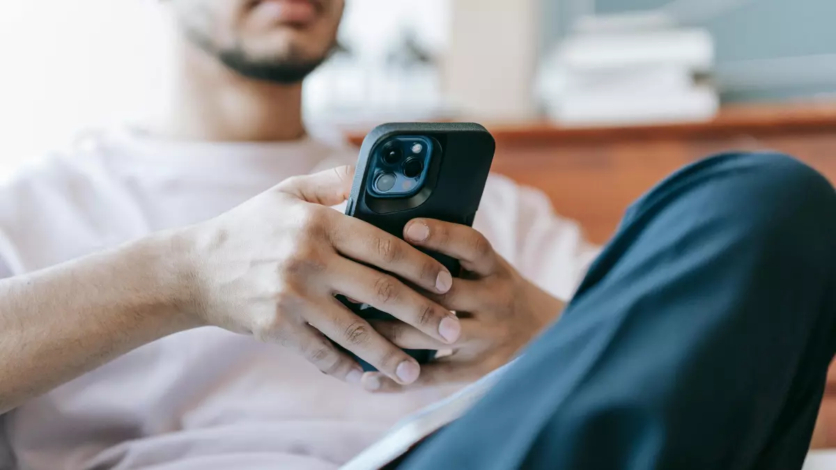 A man is using his phone while sitting down.