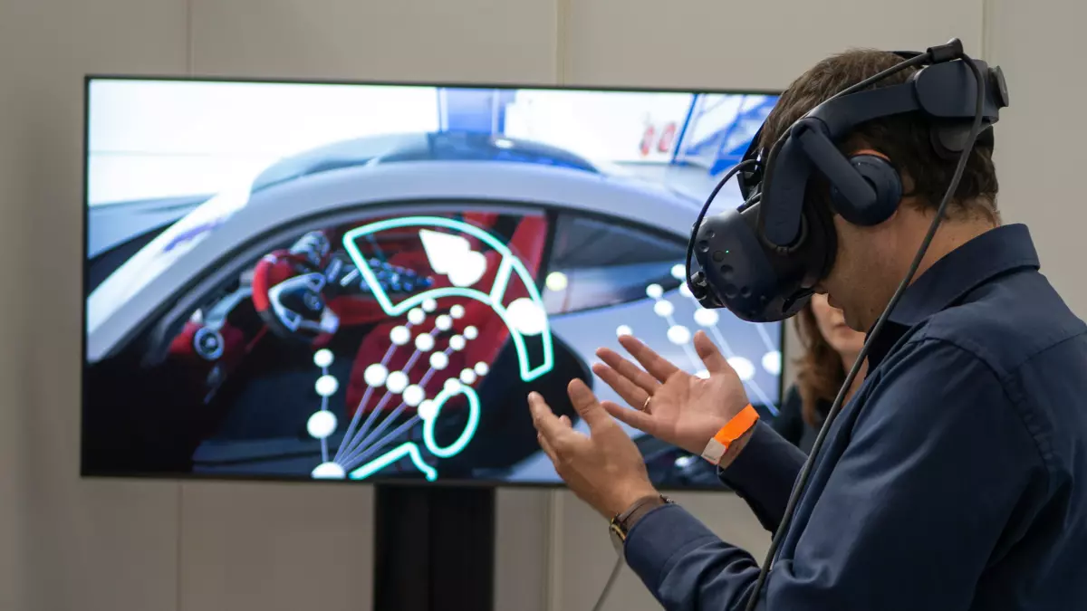 A man wearing VR goggles interacts with a screen showing virtual car interior data visualizations.