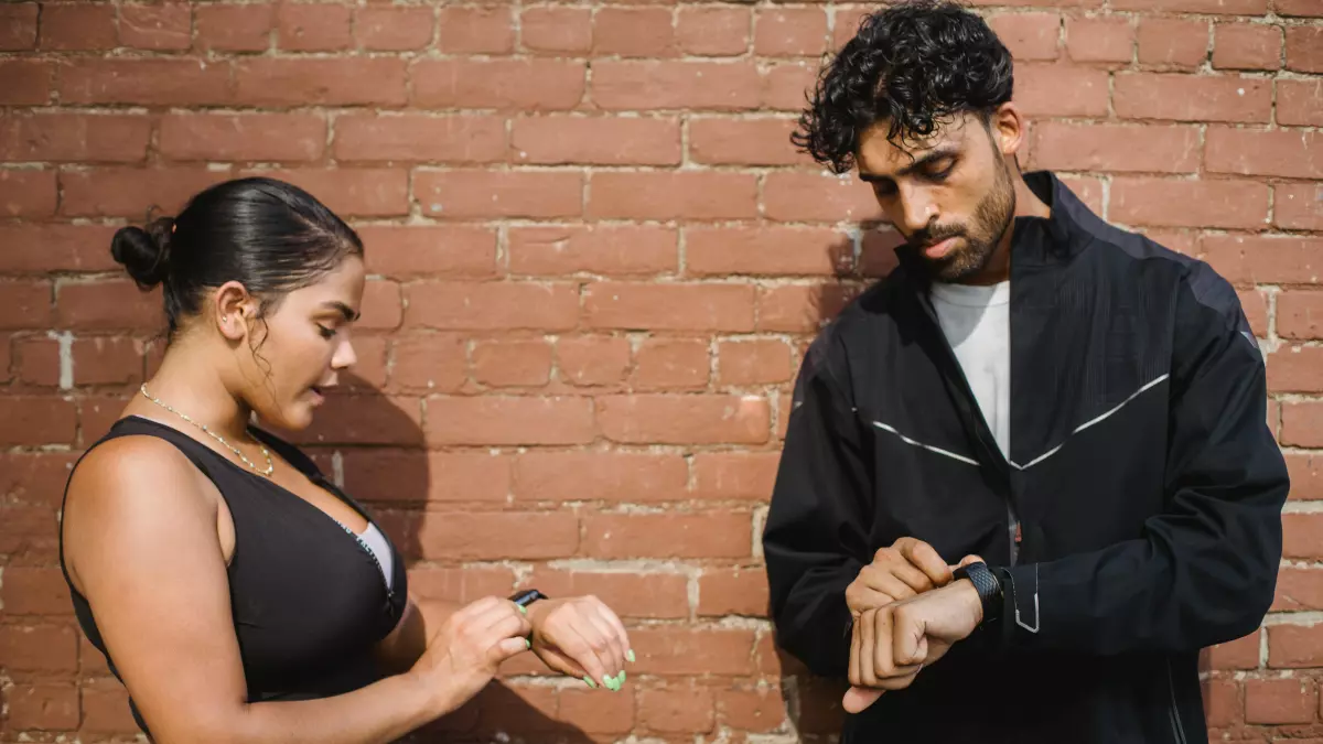 Two people are wearing smartwatches on their wrists.