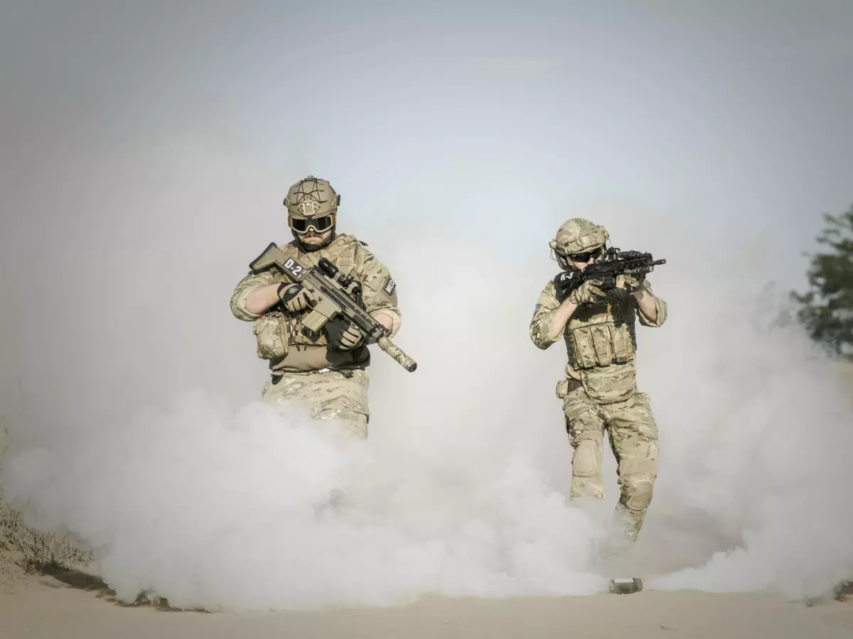 Two soldiers running through a smoke screen.