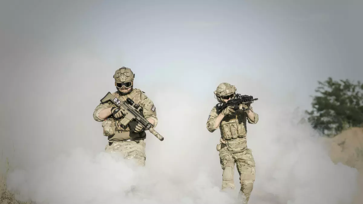 Two soldiers running through a smoke screen.