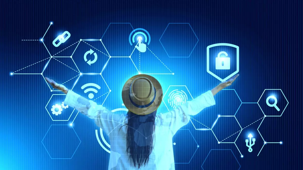 A woman wearing a white shirt and a hat, standing with her arms outstretched in front of a blue futuristic background, with a series of hexagonal graphic symbols of data security. 